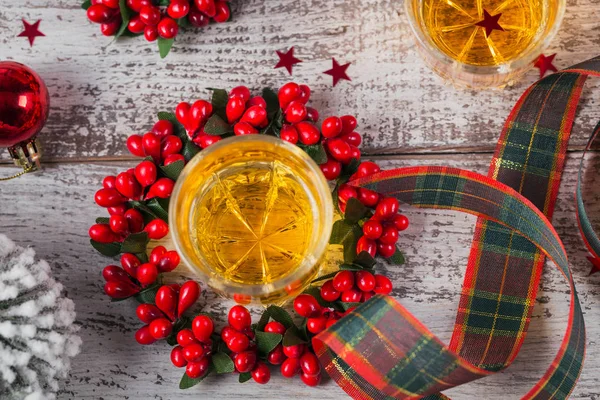 Whiskey, brandy or liquor shot and Christmas decorations on white wooden background. Seasonal holidays concept. Top view