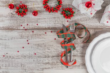 Beyaz ahşap masa üzerinde Noel ve yeni yıl süslemeleri ile kış yer ayarı. Noel yemeği için festival tablo ayarı. Metin kopyalama yeri olan üstten görünüm