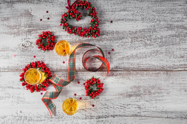 Whiskey, brandy or liquor shot and Christmas decorations on white wooden background. Seasonal holidays concept. Top view