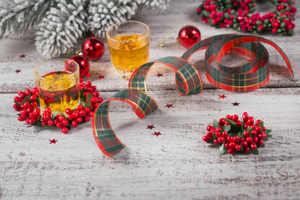 Whiskey, brandy or liquor shot and Christmas decorations on white wooden background. Seasonal holidays concept.