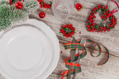 Beyaz ahşap masa üzerinde Noel ve yeni yıl süslemeleri ile kış yer ayarı. Noel yemeği için festival tablo ayarı.
