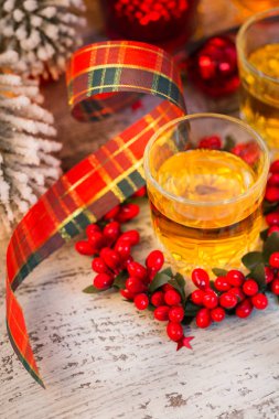 Viski, konyak ya da likör atış ve Noel süslemeleri Beyaz ahşap zemin üzerinde. Mevsimlik tatil kavramı.