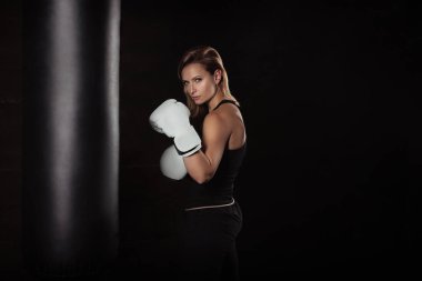 Boks eldivenleri karanlık Studio kameraya seyir spor sarışın kadın. Güçlü kadın kavramı.