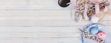 Paskalya sofra söğüt dalları, renkli yumurta ve çatal bıçak takımı. Bahar tatil kavramı. Uzun geniş afiş