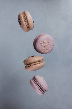 Tatlı macarons çekimde gri arka plan üzerine düşen Fransız. Pastel renkli uçan bademli kurabiye kurabiye. Gıda, mutfak ve pişirme kavramı
