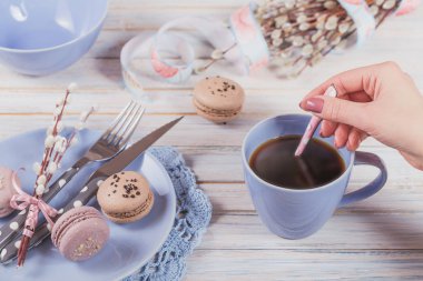 Paskalya sofra kahve, acıbadem kurabiyesi kurabiye, söğüt dalları ve çatal bıçak takımı ile. Kadın bir kaşık tutan. Bahar tatil kavramı