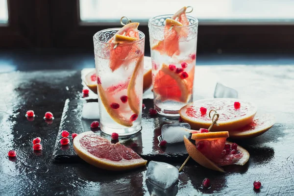 Greyfurt ve nar kokteyl ya da serinletici yaz içeceği ezilmiş buz ve köpüklü su ile mocktail,