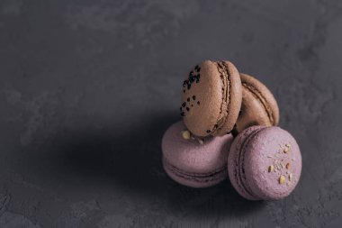 Tatlı Fransız macarons gri beton zemin üzerine yığını. Pastel renkli kurabiye kurabiye. Gıda, mutfak, ekmek ve pişirme kavramı