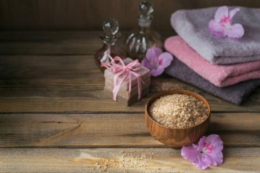 Deniz tuzu, doğal el yapımı Sabun, doğal kozmetik yağı ve renkli havlu ile açelya çiçek rustik ahşap zemin üzerinde. Sağlıklı cilt, yüz ve vücut bakımı. Spa ve saunada kavramı