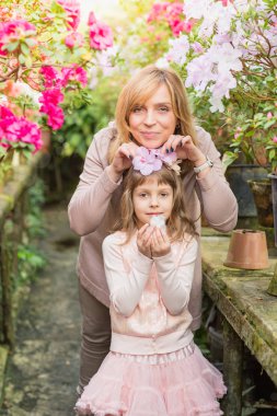 Anne ve kız carying bitkiler, serada birlikte vakit. Açelya çiçek. Botanik Bahçesi, tarım, bahçecilik sanayi kavramı çiçek
