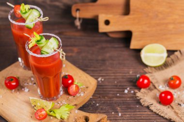 İki bardak domates suyu taze domates, cucum ile dekore edilmiştir.