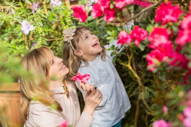 Anne ve kız carying bitkiler, serada Bahçe