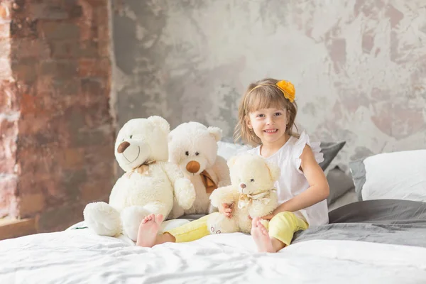 Retrato de niña divirtiéndose sentada y jugando con un Ted — Foto de Stock