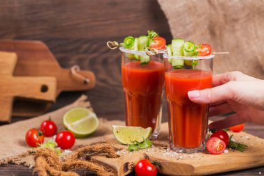 İki bardak domates suyu taze domates, cucum ile dekore edilmiştir.