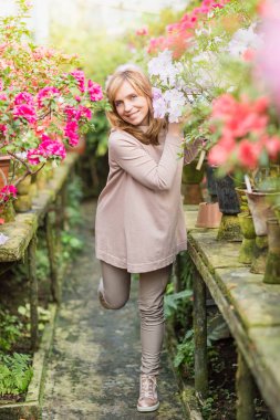 Bitkilerin sulama ve Bahçe serada güzel kadın.