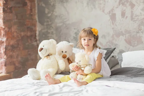 Retrato de niña divirtiéndose sentada y jugando con un Ted — Foto de Stock