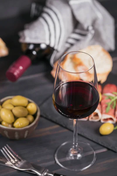 Glass of red wine with slices of cured ham or Spanish jamon serr — Stock Photo, Image