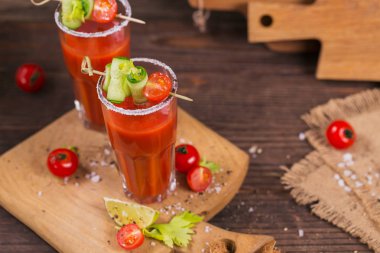 İki bardak domates suyu taze domates, cucum ile dekore edilmiştir.