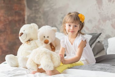 Oturma ve ted ile oynarken eğleniyor kız çocuk portresi