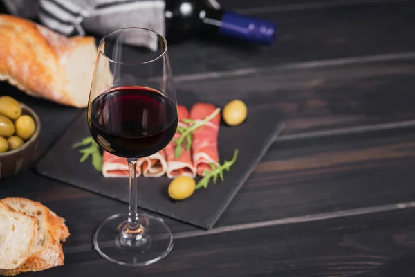 Ποτήρι κόκκινο κρασί με φέτες ζαμπόν ή ισπανικό Τζαμού — Φωτογραφία Αρχείου