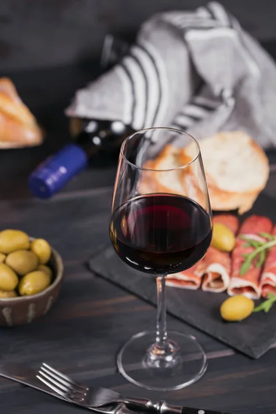 Glas rode wijn met plakjes rauwe ham of Spaanse Jamon Serr — Stockfoto