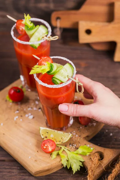 İki bardak domates suyu taze domates, cucum ile dekore edilmiştir.