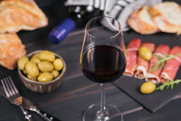 Glas Rotwein mit Scheiben Schinken oder spanischem Marmeladenserr — Stockfoto