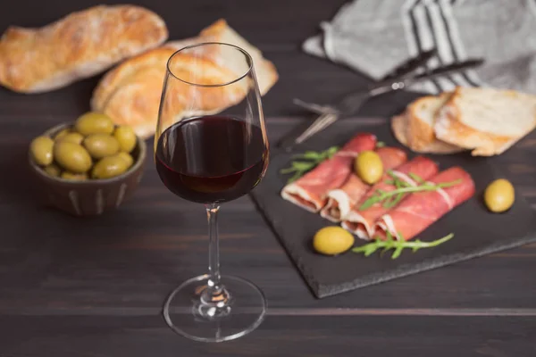 Glass of red wine with slices of cured ham or Spanish jamon serr — Stock Photo, Image