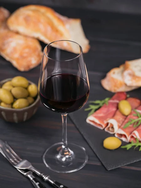 Glass of red wine with slices of cured ham or Spanish jamon serr — Stock Photo, Image