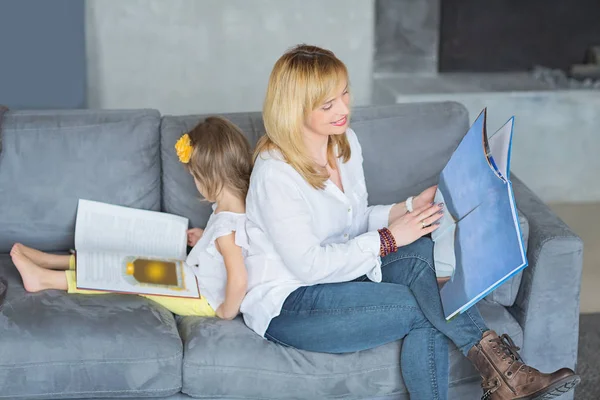 Madre e hija están jugando, leyendo un libro, sentadas — Foto de Stock