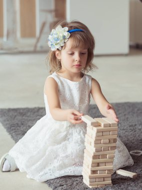 Çocuk kız çocuk parkında tahta bloklar inşa ediyor. Kız çocuk oynuyor. 