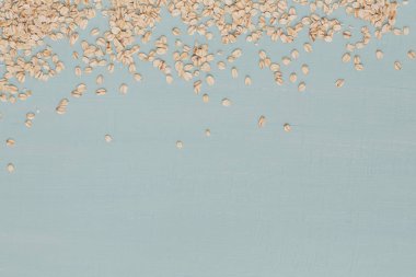 Açık mavi arka planda kuru yulaf ezmesi. Buğday tohumu.