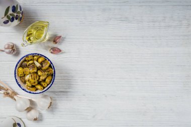 Sarımsak ile ızgara zeytin, zeytin yağı ve rustik woode üzerinde baharatlar