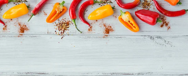 Κάτοψη των ανάμικτων μπαχαρικών και πολύχρωμες πιπεριές σε λευκό ξύλινο τραπέζι. Μπαχαρικά φόντο με δωρεάν μπαχαρικό — Φωτογραφία Αρχείου