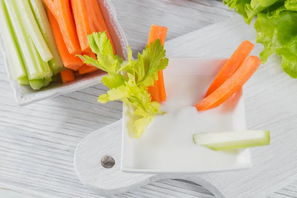 Healthy breakfast with yogurt, celery and carrot sticks. Diet and Healthy snack food.