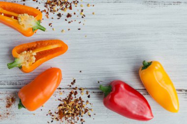 Çiğ organik renkli biber ve beyaz ahşap arka planda çeşitli baharatlar. Gıda çerçevesi için baharatlar.