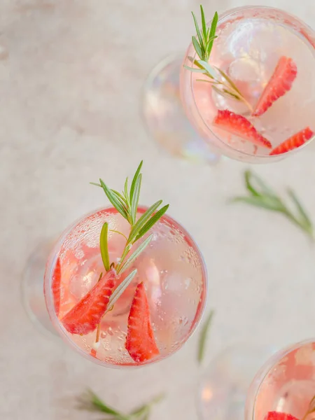 Bebida de verano con vino espumoso blanco. Cóctel casero de frutas refrescantes o ponche con champán, fresas, cubitos de hielo y romero sobre fondo claro. —  Fotos de Stock