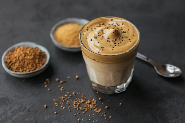 Egy pohár jeges Dalgona kávé, trendi bolyhos tejszínhab kávé és tej sötét háttérrel. — Stock Fotó