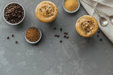 Dalgona kremalı kahve, hazır, kremalı, buzlu kahve. Kahve, süt ve buzlu kokteyl. Gri arka plan modeli. Metin için kopyalama alanı olan modaya uygun içecek arkaplanı.