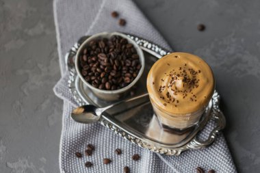 Dalgona kremalı kahve, hazır, kremalı, buzlu kahve. Kahve, süt ve buzlu kokteyl. Gri arka plan modeli. Metin için kopyalama alanı olan modaya uygun içecek arkaplanı.