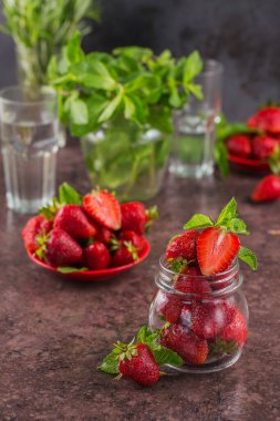 Ev yapımı çilek reçeli ya da olgun böğürtlen ve nane yapraklı cam kavanozda marmelat. Eski cam bir kavanozda organik olgun çilek.
