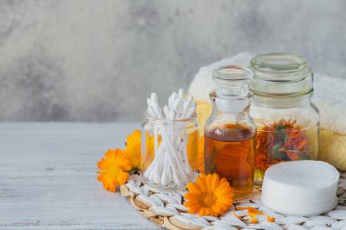 Bir şişe kadife çiçeği tentürü ya da taze takviye çiçekleri ve pamuklu ped ve beyaz arka planda çubuklar. Doğal bitkisel alternatif tıp, şifa ve şifalı bitkiler..