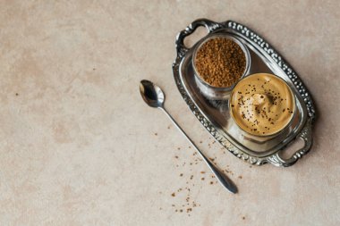 Dalgona kremalı kahve, hazır, kremalı, buzlu kahve. Açık bej arka planda kahve, süt ve buz karışımı. Metin için kopyalama alanı olan modaya uygun içecek arkaplanı.