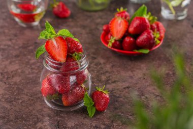 Ev yapımı çilek reçeli ya da olgun böğürtlen ve nane yapraklı cam kavanozda marmelat. Eski cam bir kavanozda organik olgun çilek.