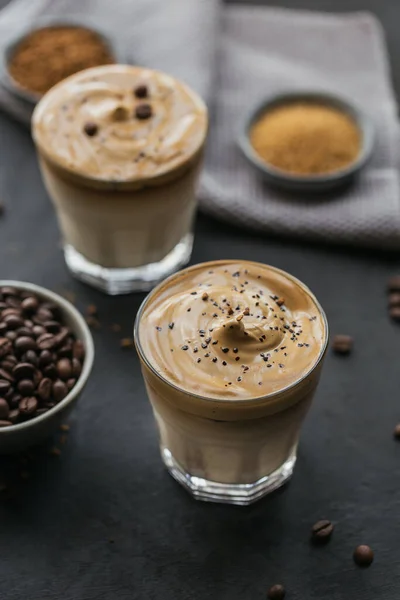 Gelas Iced Dalgona Coffee, trendy fluffy creamy kopi dan susu di latar belakang hitam. — Stok Foto