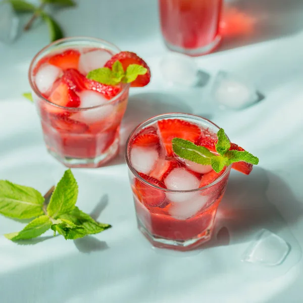 Açık mavi arka planda çilekli soda bardakları. Yaz sağlıklı detoks limonata, kokteyl ya da başka bir içki geçmişi. Az alkol, alkolsüz içecekler, vejetaryen ya da sağlıklı beslenme konsepti.