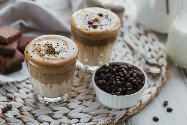 Gelas Iced Dalgona Coffee, trendy fluffy creamy kopi dan susu dengan latar belakang kayu putih. — Stok Foto