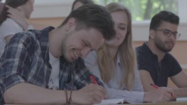 Öğrenciler not defterinde yazılı gülüyor.