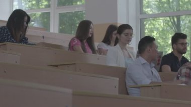 Art arda sıralı sınıfta ders sırasında oturan öğrenciler.