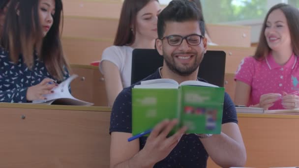 Geconcentreerd lachende student lezen in de klas universitys. — Stockvideo